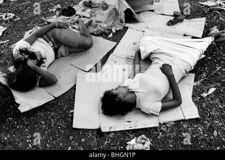 Les filles du Nicaragua, une dépendance à l'inhalation de colle, dormant sur le carton dans le parc, Managua, Nicaragua. Banque D'Images