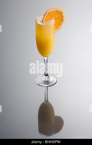 Cocktail Mimosa avec orange slice garnir sur fond gris avec reflet Banque D'Images