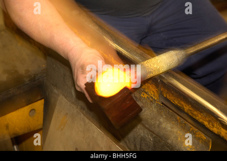 L'homme en forme du cristal dans un moule en bois à l'extrémité de tube de la tige de verre soufflé Banque D'Images