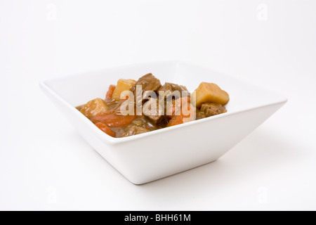 Ragoût de boeuf ou du goulasch dans bol blanc contre isolé sur fond blanc. Banque D'Images