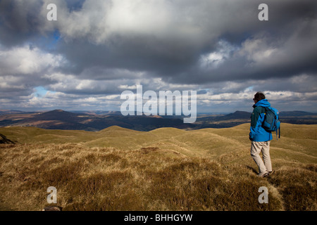 Walker à la femme à travers les montagnes dans le sud du Pays de Galles de l'Ardanaiseig UK Banque D'Images