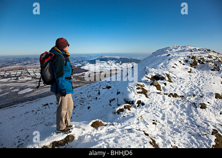 Walker femelle en haut de la Montagne du Pain de Sucre en hiver à la recherche vers le sommet et dans la distance Skirrid Wales UK Banque D'Images