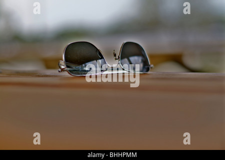 Capture HDR de aviator sunglasses assis sur une table de pique-nique avec une très faible profondeur de champ. Banque D'Images