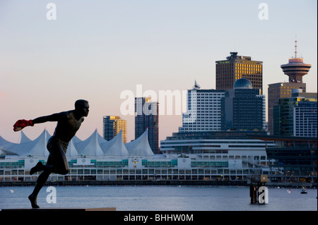 Statue de Harry Jerome coureur olympique dans le parc Stanley de Vancouver avec la ville en arrière-plan. Banque D'Images