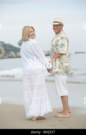 Stand Senior couple holding hands on beach Banque D'Images