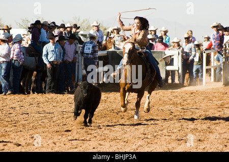 Une cowgirl est concurrentiel dans le breakaway roping évènement durant un rodéo shcool Banque D'Images