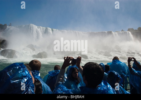 Les touristes en bleu d'imperméables et American Falls vu de Maid of the Mist boat sur la rivière Niagara Banque D'Images