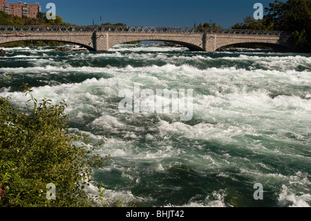 Les rapides turbulents de la rivière Niagara coulent sous un pont de pierre juste avant Niagara Falls, NY, États-Unis. Vue panoramique sur les courants fluviaux. Banque D'Images