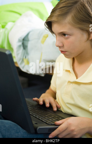 Preteen boy using laptop computer Banque D'Images