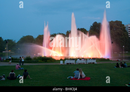 Parc Planten un Blomen, Wasserspiele bei Daemmerung, Menschen auf Wiese, Hamburg, Deutschland Banque D'Images