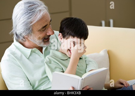 Senior man reading histoire à petit-fils Banque D'Images