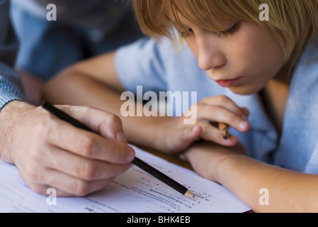 École primaire d'être aidé par l'enseignant en classe Banque D'Images