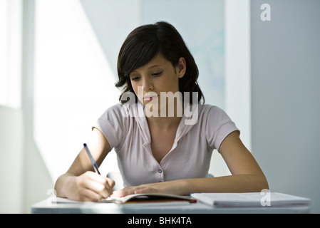 Adolescente en se concentrant sur l'affectation en classe Banque D'Images