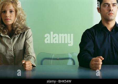 L'homme et la femme assis à table avec chaise vide entre eux, les deux work Banque D'Images