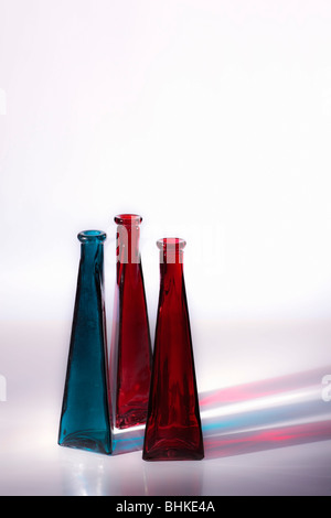 Rouge et bleu de vases en verre décoratif. Côté flou artistique, allumé par des réflexions. Isolées. Copier l'espace. Banque D'Images