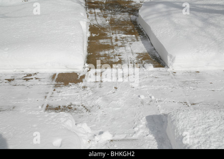 Effacée de la neige sur le trottoir et les cours avant en hiver Banque D'Images