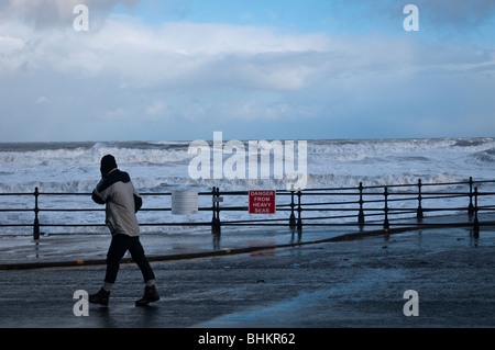 Personne marche par le fracas des vagues de tempête hivernale, Scarborough Banque D'Images