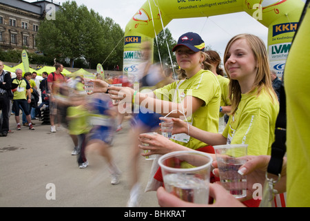 Deux filles aidant avec verres à eau pour les coureurs. Marathon à Dresden, Allemagne Banque D'Images
