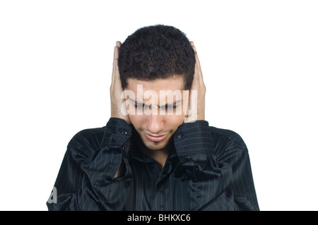 Jeune homme portant du Moyen-Orient chemise noire et permanent la tête dans les mains sur un fond blanc. Banque D'Images