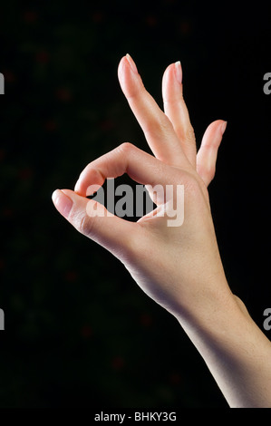 Woman's hand showing ok sign sur un fond noir Banque D'Images