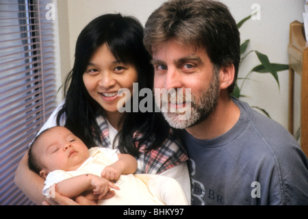 Maman mère sino-américaine papa père blanc avec bébé minuscule sourire portrait de famille Banque D'Images