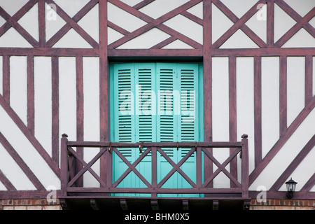 Beuvron-en-Auge, en Normandie, France. Volets turquoise et balcon en bois de maison de village à colombages. Banque D'Images