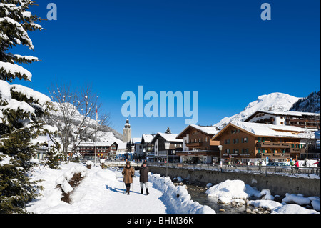 Personnes âgées en train de marcher le long de la rivière dans le centre de la station de ski d'Arlberg Lech, région, Vorarlberg, Autriche Banque D'Images