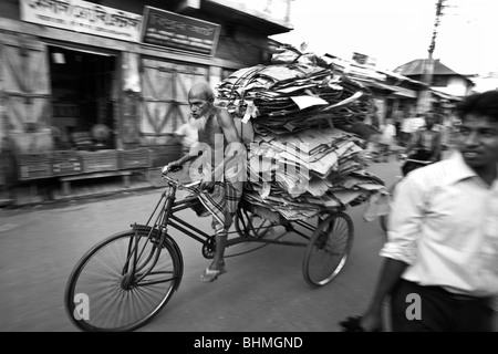 Un cycliste à Barisal Bangladesh transporte pour recyclage de carton sur son pousse-pousse. Banque D'Images