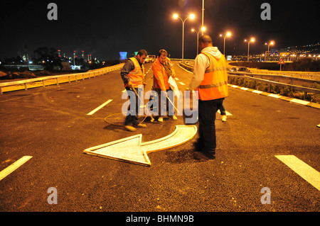 Le marquage routier peinture les travailleurs de nuit Banque D'Images