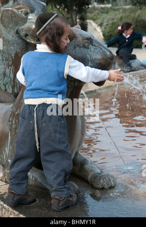 Jeune garçon juif orthodoxe jouant à la fontaine Lion à Jérusalem Banque D'Images