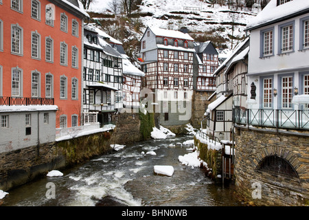 Des maisons à colombages le long de la rivière Rur à Monschau dans la neige en hiver, Eifel, Rhénanie du Nord-Westphalie, Allemagne Banque D'Images