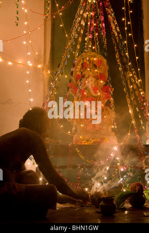 Un Brahmane bénit une statue de Ganesh, le dieu éléphant du panthéon hindou, au cours de Ganpati à Puri, Orissa, Inde Banque D'Images