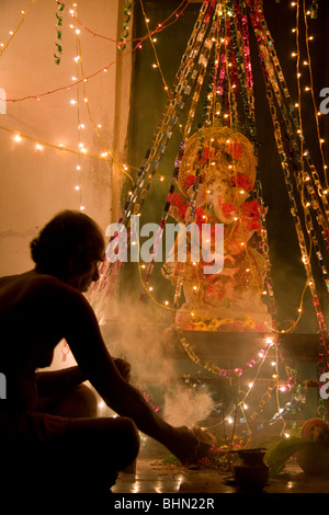 Un Brahmane bénit une statue de Ganesh, le dieu éléphant du panthéon hindou, au cours de Ganpati à Puri, Orissa, Inde Banque D'Images