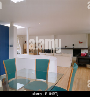 Chaises bleues et table en verre dans d'une salle à manger et salle de séjour en appartement de conversion loft Banque D'Images