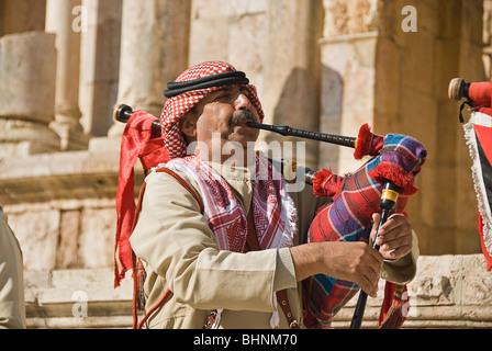 Man blowing le pipa à les vestiges romains de Jerash, Jordanie, Asie. Banque D'Images