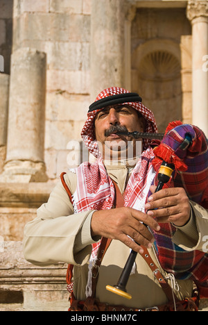Man blowing le pipa à les vestiges romains de Jerash, Jordanie, Asie. Banque D'Images