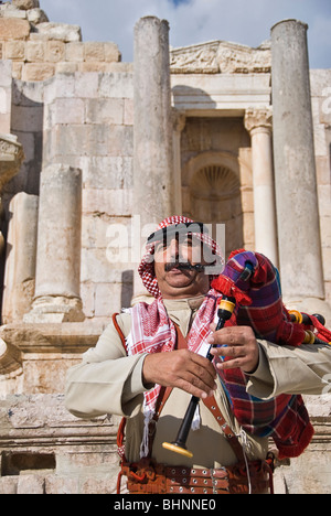 Man blowing le pipa à les vestiges romains de Jerash, Jordanie, Asie. Banque D'Images