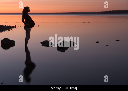 Silohuette de femme enceinte au coucher du soleil, Clear Lake, Manitoba, Canada Banque D'Images