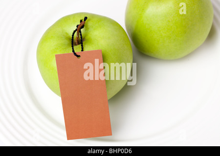 La pomme verte avec étiquette on white plate Banque D'Images