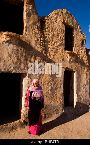 Femme berbère en face de son ancien village berbère antique à Ksar Djerba Tunisie près de Food & Drink en Afrique Banque D'Images