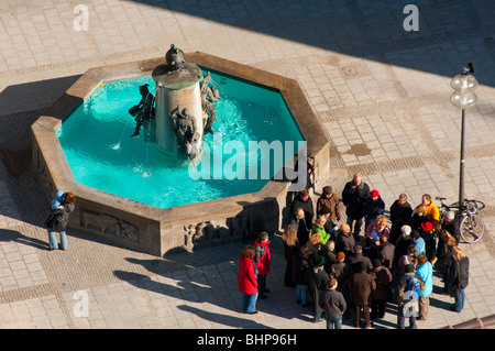 Tour group rassembler près d'une fontaine dans la place Marienplatz, Munich, Allemagne Banque D'Images