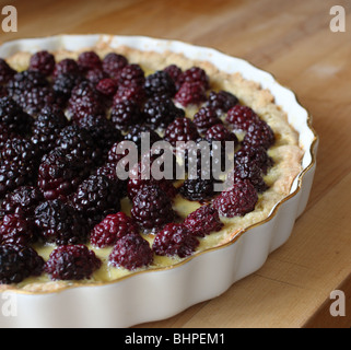 Tarte Blackberry dans un plat à tarte chine doré sur une planche à découper en bois Banque D'Images