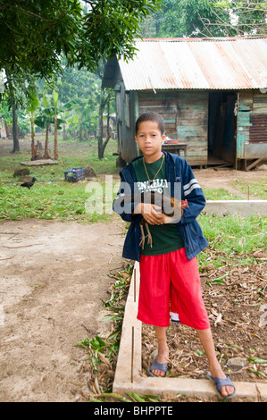 Garçon heureux locale avec poulet poule pet nicaraguayenne nicaragua jungle house animal sourire souriant éditorial typique de l'architecture Banque D'Images