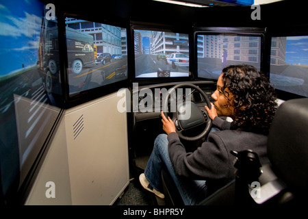 Une femme agent de police Haute vitesse pratiques compétences de conduite dans une auto-patrouille simulateur avec un vrai volant et siège. Banque D'Images