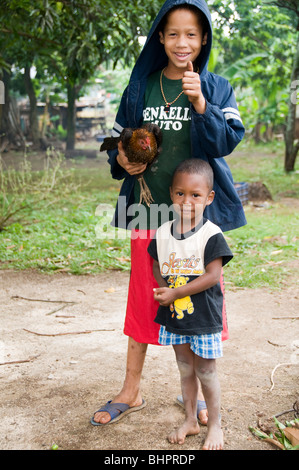 Les deux garçon peu jeunes amis enfant enfants heureux locale nicaragua pet nicaraguayenne hen chicken jungle house animal arch Banque D'Images