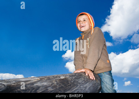 Bel enfant assis sur un journal, jouer Banque D'Images