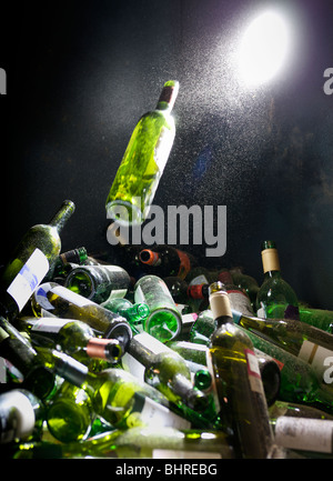 Une bouteille en verre d'être poussé dans un bac de recyclage de verre Banque D'Images