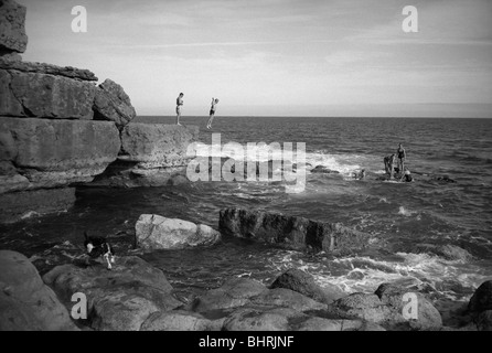 Les gens de sauter des rochers dans la mer Banque D'Images