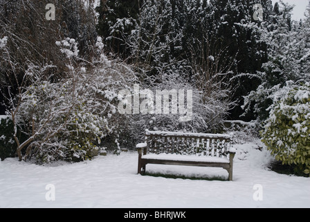 Banc à St Leonards Church souvenir jardin couvert de neige, Heston West London, UK Banque D'Images