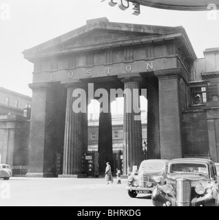 En dehors de l'arche de l'entrée principale de la gare de Euston, Camden, London, 1952. Artiste : Henry Grant Banque D'Images